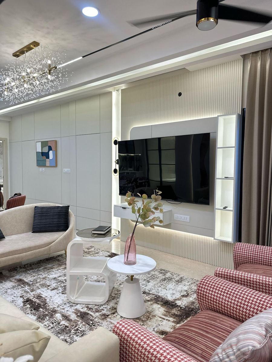 Living room with backlit TV wall and pink checked armchairs